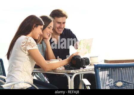 Tre felici turisti guida controllo seduti in un caffè in vacanza Foto Stock