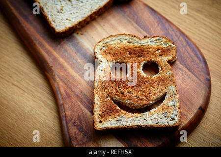 Fetta di pane tostato marrone sul tagliere Foto Stock