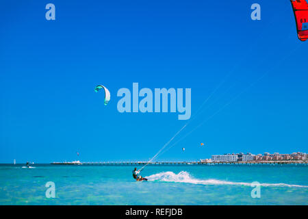 Egitto, Hurghada - 30 Novembre, 2017: i kiters di scorrimento sul mare rosso superficie. Il popolari professionale e di attrazione turistica. Il Panorama Bungal Foto Stock