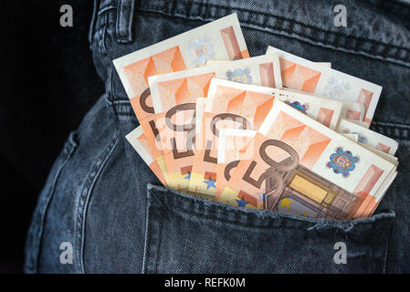 Euro banconote denaro in tasca dei jeans. Concetto di gente ricca, salvataggio o spendere soldi. Cinquanta euro bills cadano fuori. Facili da rubare i soldi. Irrespo Foto Stock