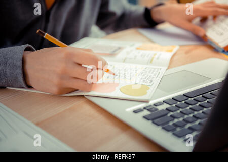 Studente scrivere appunti su una video conferenza Foto Stock