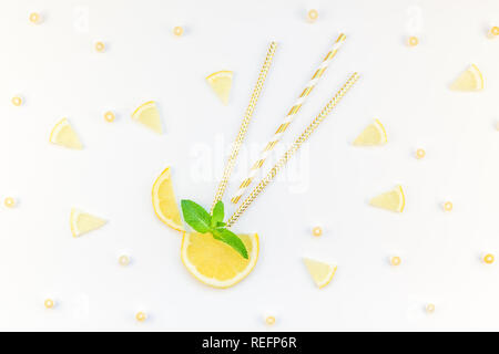 Creative overhead flatlay vista dall'alto di agrumi fette di limone e menta erbe Lascia tavolo bianco sfondo con copyspace. Estate calda limonata ristoro co Foto Stock