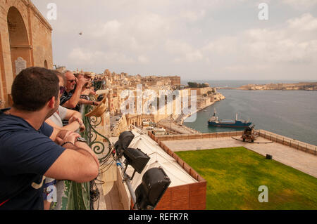 Ai visitatori di ammirare il panorama sul Porto Grande e le città vicine da Upper Barrakka Gardens a La Valletta, Malta. Foto Stock