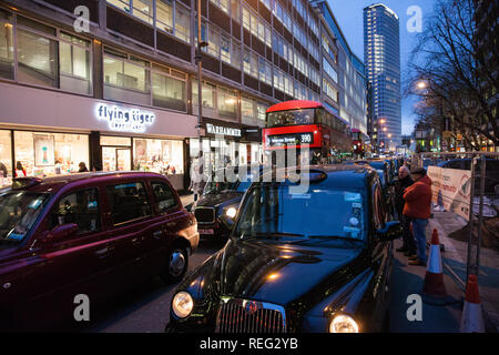 Londra, Regno Unito. Il 21 gennaio, 2019. Autisti di taxi autorizzati o Black Cab Driver, blocco Tottenham Court Road in segno di protesta contro una sentenza emessa dal Consiglio di Camden che i taxi, camion e automobili saranno vietati dalla strada da 8am-7pm dal lunedì al sabato con effetto a partire dal mese di marzo 2019. La strada e vicino a Gower Street, sarà anche trasformato da uno a due vie di traffico. Credito: Mark Kerrison/Alamy Live News Foto Stock