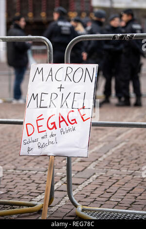 Aachen, Germania. Il 22 gennaio, 2019. Il segno di un dimostrante con la dicitura "acron e Merkel - scompare. Arrestare la politica per i ricchi" si appoggia contro una barriera alla piazza del municipio. Il Cancelliere Merkel e il presidente francese Macron firmare il rinnovo del trattato di amicizia tra i due paesi in Aachen. Credito: Marius Becker/dpa/Alamy Live News Foto Stock