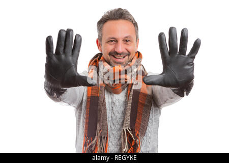 Uomo sorridente con espressione cordiale presentazione nero Guanti in pelle mostrando le palme che indossa una sciarpa e il ponticello come l'inverno fashion concept isolati su w Foto Stock