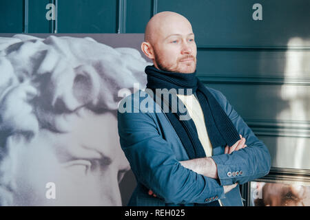 Ritratto di attraente successo adulto uomo calvo critico d'arte storico con la barba in sciarpa in galleria d'arte Foto Stock