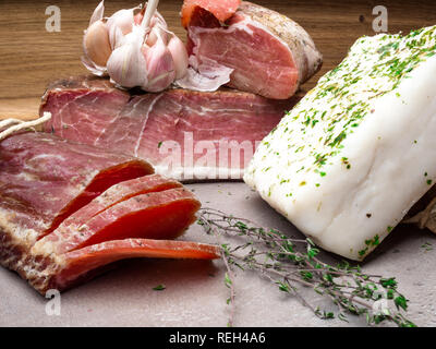 Pezzetti di pancetta di maiale salata grasso a scatti, lardo, prosciutto cotto un alimento sano con pranami le spezie e le erbe aromatiche timo, aglio Foto Stock