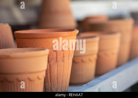 Vasi di terracotta allineate su un ripiano Foto Stock