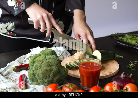 Ragazza taglia verdure con un coltello da cucina Foto Stock