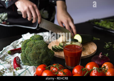 Ragazza taglia verdure con un coltello da cucina Foto Stock