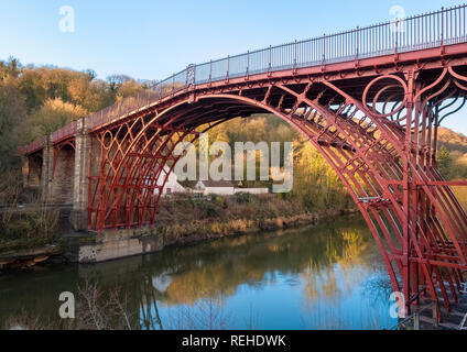 Il sole d'inverno mette in risalto il colore rosso del ponte di ferro sul fiume Severn di Ironbridge, Shropshire, Inghilterra, Regno Unito Foto Stock