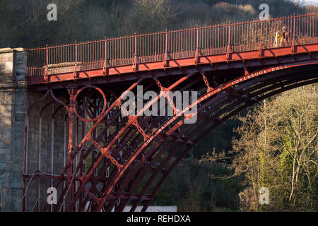 Il sole d'inverno mette in risalto il colore rosso del ponte di ferro sul fiume Severn di Ironbridge, Shropshire, Inghilterra, Regno Unito Foto Stock