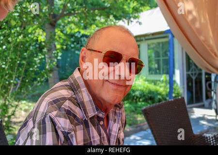 Ritratto di sorridere senior Uomo con occhiali guardando la fotocamera Foto Stock