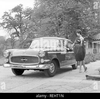 La guida negli anni cinquanta. Una giovane donna è in piedi accanto a una vettura Opel Kapitän, parlando di un uomo dietro la ruota. Ella è di moda il vestito in un tipico degli anni cinquanta vestito. Foto Kristoffersson Ref CB93-3 Foto Stock