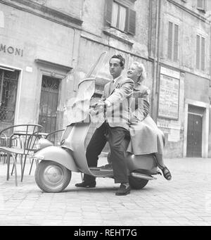 Matura in Italia negli anni cinquanta. Una giovane coppia su una Vespa scooter guida su una strada a Milano Italia 1950. Foto Kristoffersson Ref AY28-13 Foto Stock