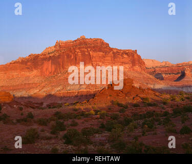 Stati Uniti d'America, Utah, parco nazionale di Capitol Reef, Tramonto sul castello e altre formazioni di arenaria lungo il Waterpocket Fold; vista est dal punto panoramico. Foto Stock