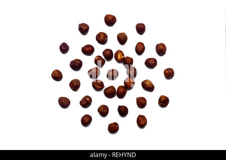 Una raccolta di nocciole si trovano nella forma di un cerchio o sun isolato su un fondo bianco con un tracciato di ritaglio. Modello di nocciole Foto Stock