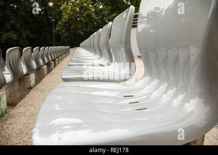File di sedili in plastica nello stadio outdoor su soleggiate giornate estive Foto Stock