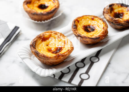 Crostata di uova sul vassoio e tradizionale dolce portoghese, Pastel de nata, crema pasticcera crostate Foto Stock