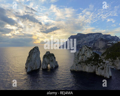 Luminose scenic si affacciano dei drammatici Faraglioni torreggianti fino dal blu luminoso acque del Mediterraneo sull'isola di Capri, Italia Foto Stock