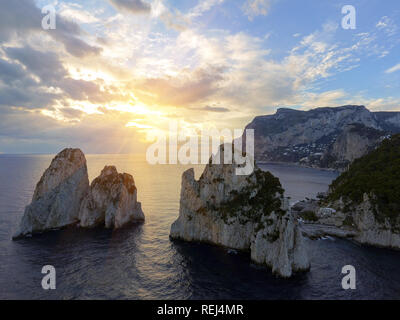 Luminose scenic si affacciano dei drammatici Faraglioni torreggianti fino dal blu luminoso acque del Mediterraneo sull'isola di Capri, Italia Foto Stock