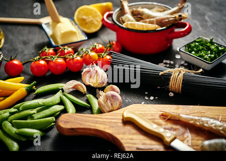 Fresche deliziose crude gamberoni in una pentola di rosso con prezzemolo, limone, burro, pomodori e peperoncino Foto Stock