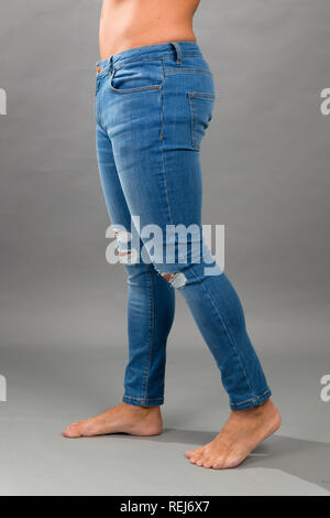 Moderno senza marchio maschio Blue skinny jeans strappati isloated su sfondo grigio Foto Stock