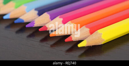 Close up di matite colorate sulla scrivania in legno Foto Stock