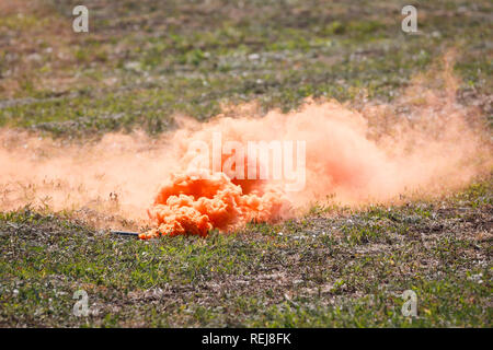 Pellet di fumo con le nuvole di fumo arancione sul campo di battaglia Foto Stock