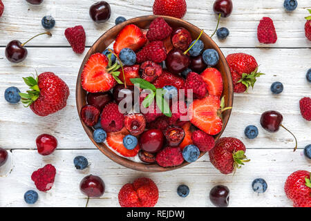 Ciotola di estate bacche con yogurt o budino di Chia con fresche lamponi, fragole, ciliegie e mirtilli. Colazione sana. vista superiore Foto Stock