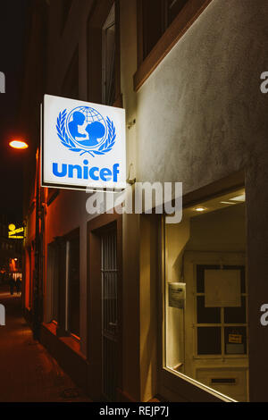 TRIER, Germania - Feb 21, 2015: Tedesco strada di notte con UNICEF insegne illuminate al di sopra della porta di ingresso della filiale locale dell organizzazione internazionale a Trier, Germania Foto Stock