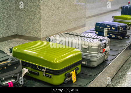 Valigia e bagagli sul nastro trasportatore in aeroporto internazionale Foto Stock