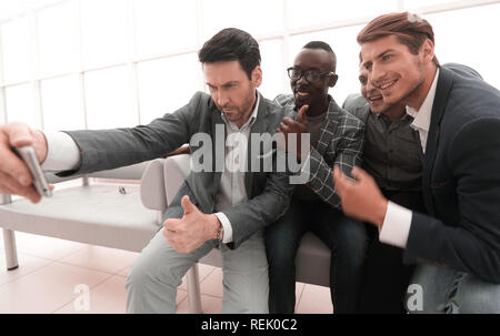 Team aziendale prende selfies nella lobby del centro business Foto Stock