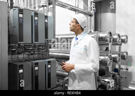 Il Tecnologo con una compressa nelle sue mani presso il caseificio Foto Stock