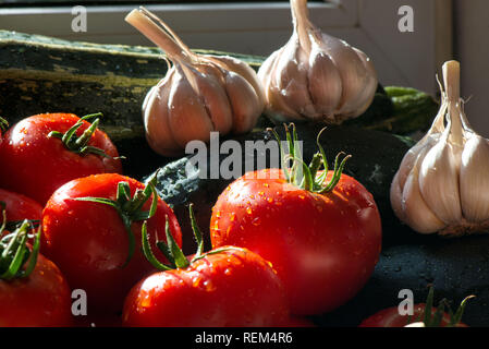 Mature raccolte fresche verdure sul tavolo. Cipolle, pomodori, aglio, pepe, zucchine in cucina. Rendendo delizioso pasto vegetariano o conserve verdure f Foto Stock