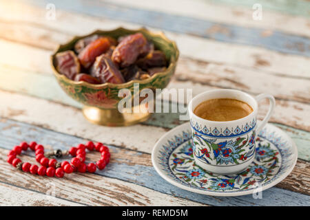 Caffè alla turca, date e rosario rosso sulla tavola turchese vista laterale Foto Stock