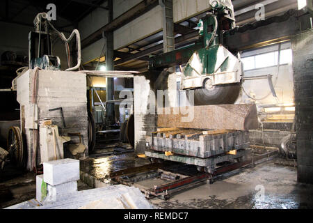 Elaborazione di granito in produzione. Il taglio di lastre di granito con una sega circolare. Foto Stock