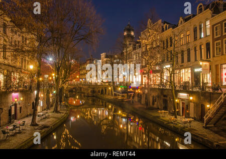 Utrecht, Paesi Bassi, 21 Gennaio 2019: canal case, pontili, alberi e le luci della città si riflettono nei dello specchio d'acqua del vecchio canale nel blu Foto Stock