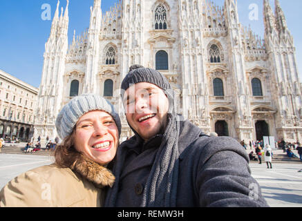 Viaggi, Italia e vacanze concetto - Happy turisti prendendo un autoritratto di fronte la Cattedrale del Duomo di Milano Foto Stock
