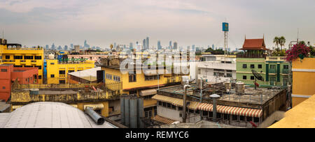 Tetti della vecchia Bangkok con il moderno skyline di Bangkok in background Foto Stock