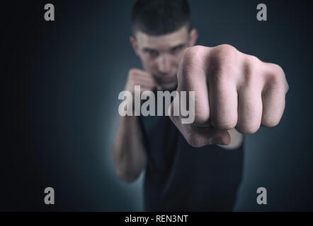 Bello athletic uomo nella boxe stand. Focus sul pugno Foto Stock