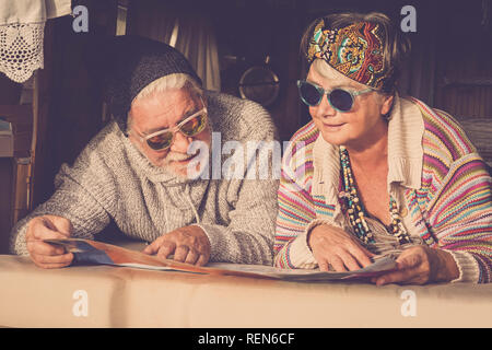 Adulti Coppia matura della popolazione caucasica stile hippy pianificazione sulla mappa il passo successivo della vita van vacanza - allegro felice l uomo e la donna in pensione e Foto Stock