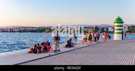 Mare Adriatico terrapieno con un faro e turisti in estate in Zadar, Croazia. Foto Stock