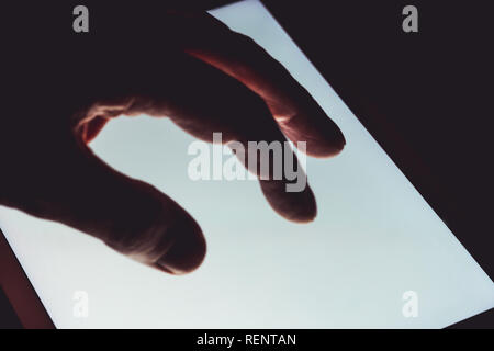 Mano con touch screen tablet business computer di notte Foto Stock