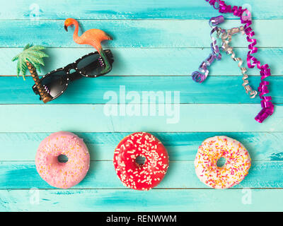 Il carnevale di turchese sfondo con ciambelle e decorazione Foto Stock