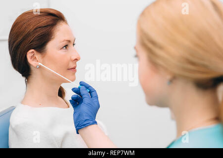 Il medico ORL controllo orecchio del paziente, donna mentre l'esame dell'orecchio Foto Stock