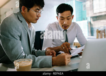 Due persone che lavorano insieme in un negozio di caffè. Colleghi di lavoro seduto presso la caffetteria tabella analizzando alcuni documenti. Foto Stock