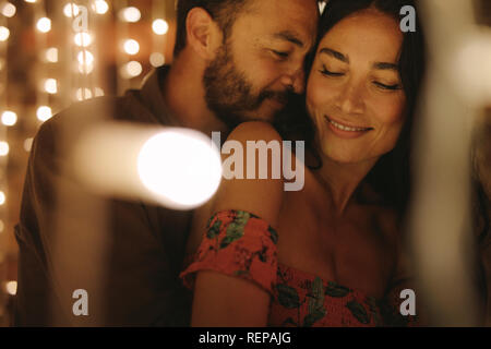 Matura in amore abbracciando e godendo di un intimo momento insieme, contro lo sfondo delle luci. Giovane facendo una romantica danza. Foto Stock