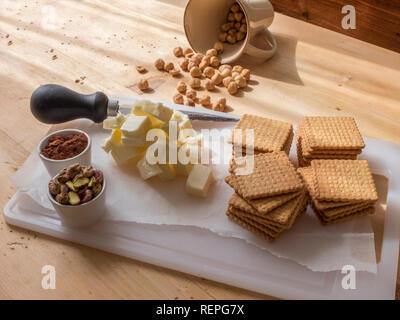 La fase di preparazione della tipica torta fatta in casa con il burro di cacao, zucchero e biscotti sbriciolati Foto Stock